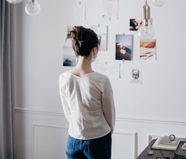 Woman looking at pictures on a white wall